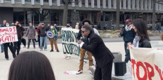 Cornel West (center, in black suit) speaking to a crowd of student activists in Harvard Science Center Plaza.