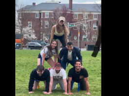 Six players stacked together in a human pyramid in Cambridge Common park.