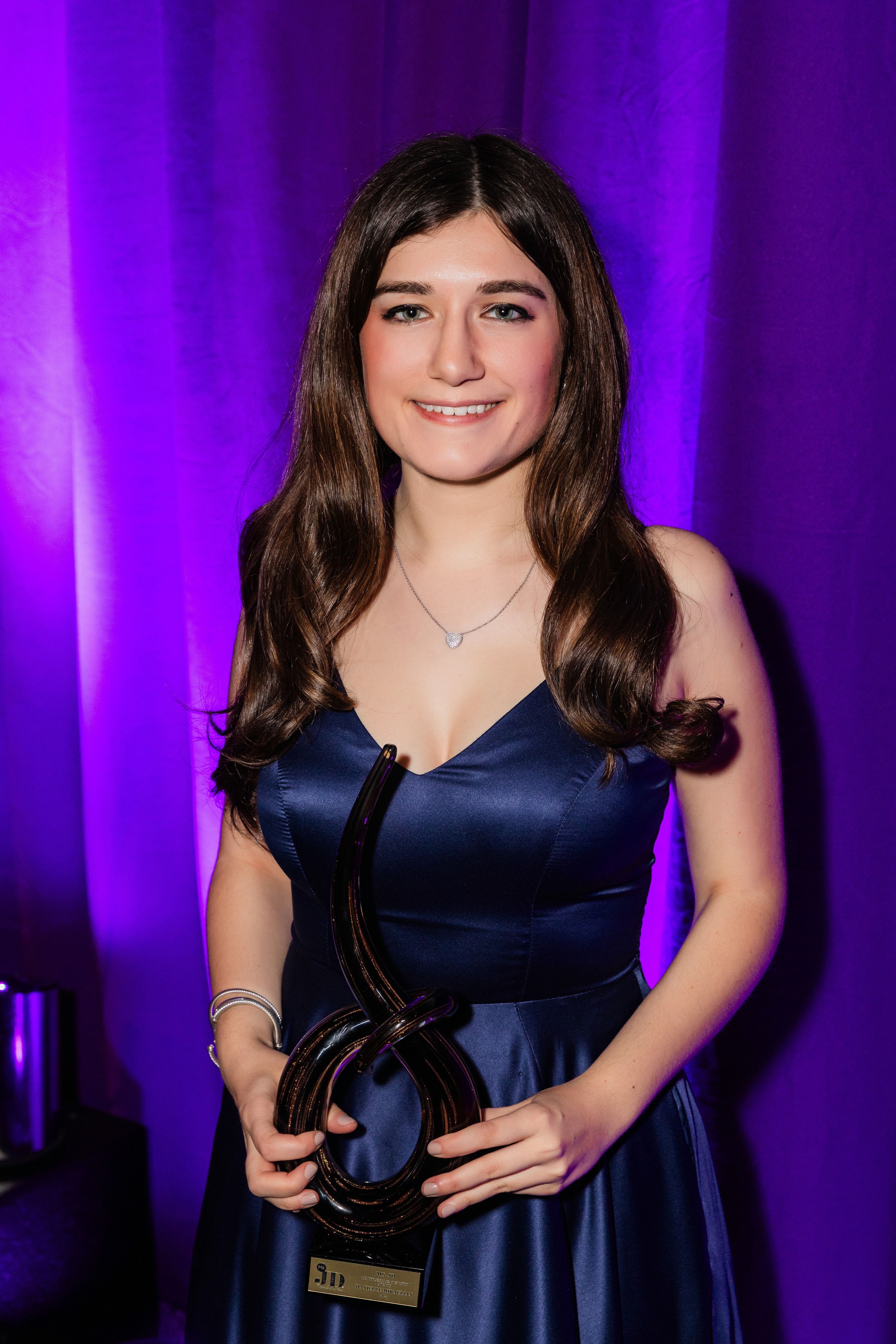 Danielle Mikaelian holding her Limitless Leadership Award.