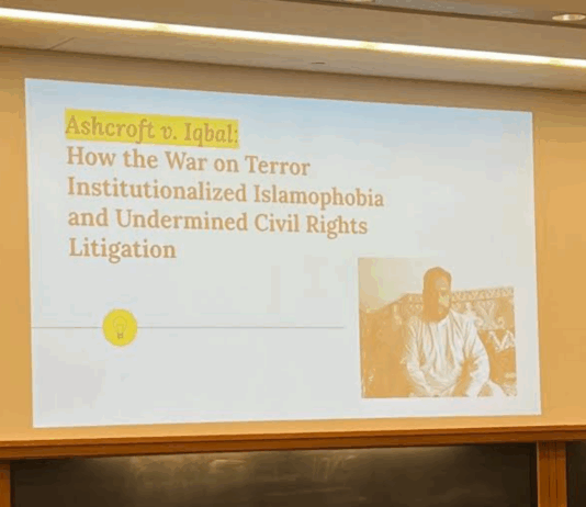 Presentation in a classroom in a Wasserstein hall section classroom reads "Ashcroft v. Iqbal: How the War on Terror Institutionalized Islamophobia and Undermined Civil Rights Litigation" (I. Bharmal, 2022).
